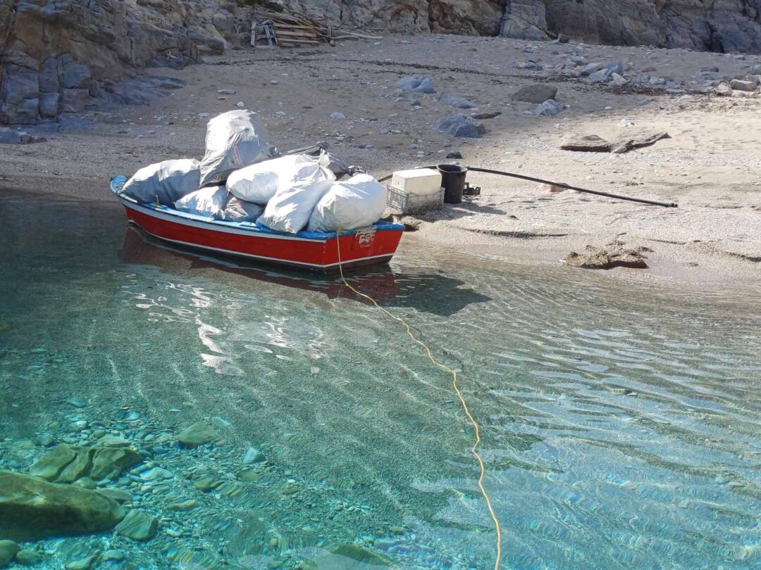 Tourisme durable : Bateau de pêche après le nettoyage d’une plage à Amorgos